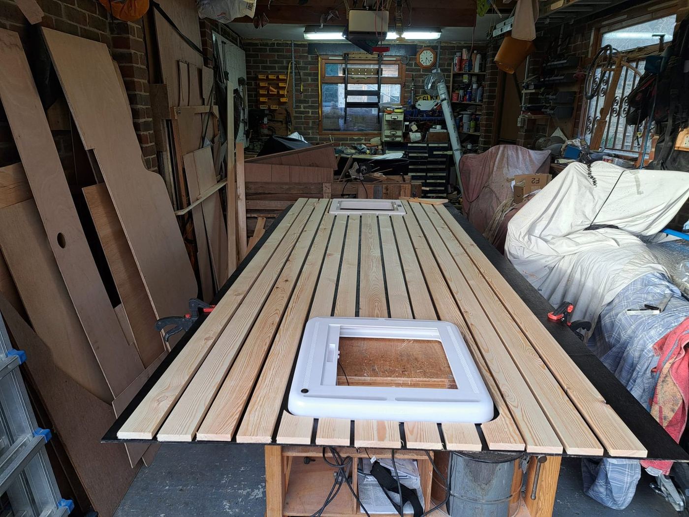 Campervan workshop wood preparation — slatted ceiling cladding laid out with skylight